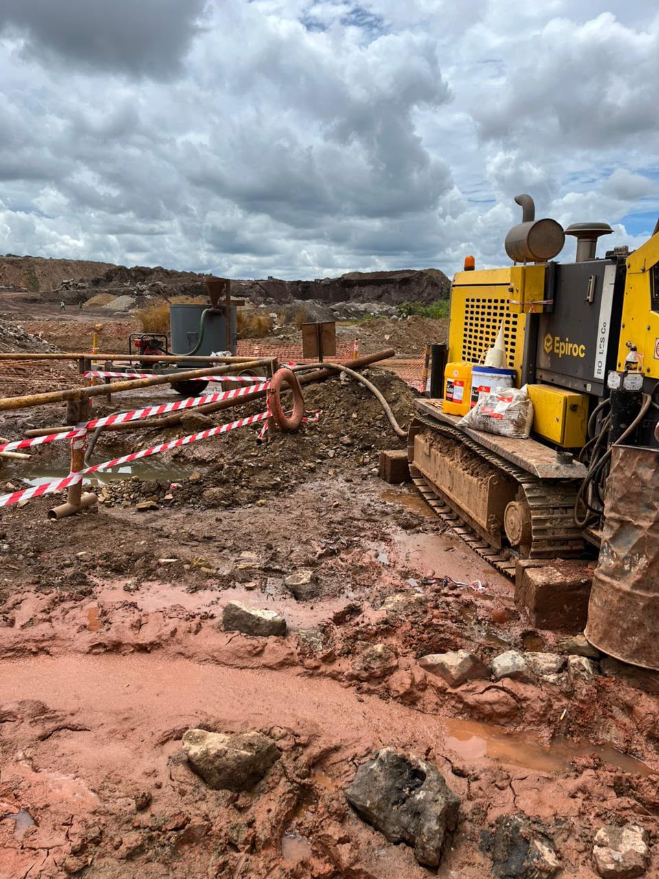 Drill rig on a muddy mine site with DrillPoint fluid products on the deck
